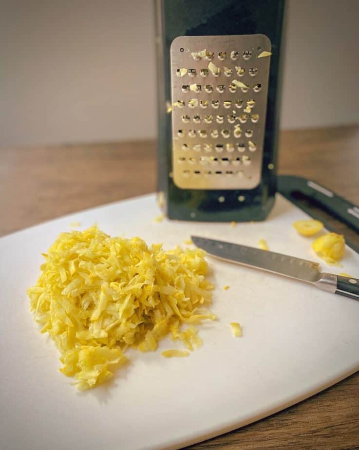 yellow summer squash that has been grated onto a cutting board with a box grater