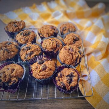 dozen healthy whole wheat blueberry summer squash muffins on a cooling rack.