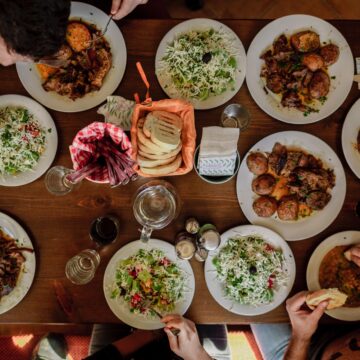 overhead shot of people eating a huge holiday meal.