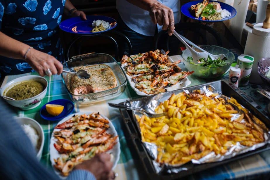 people serving themselves from a holiday potluck buffet.