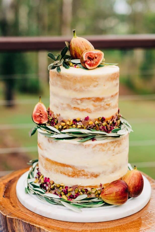semi naked cake decorated with fresh figs, chopped pistachios, and rosemary.