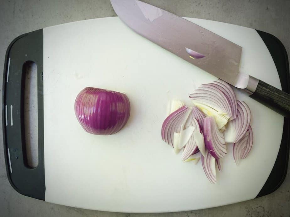 thinly sliced red onion on a cutting board.