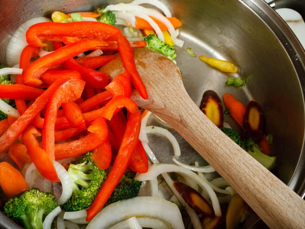 adding bell peppers to stir fry.