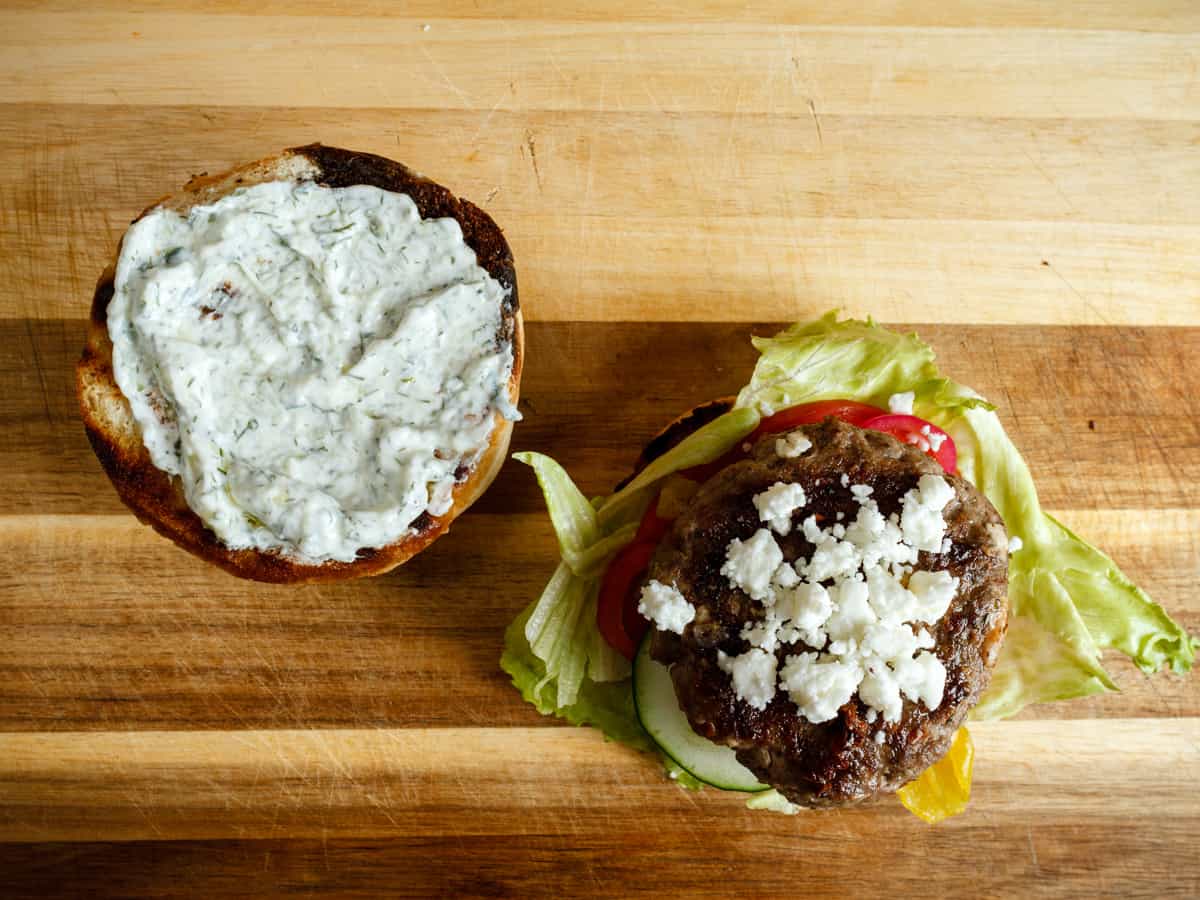 open faced shot of assembled burger with feta on top.