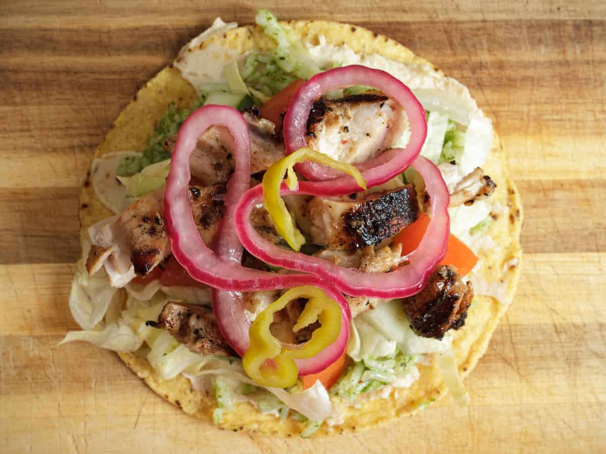 pickled red onions and pickled banana peppers added to the zhoug chicken tostada.
