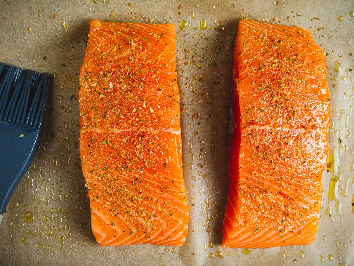 two salmon fillets seasoned with oil and spices for making fish burritos.