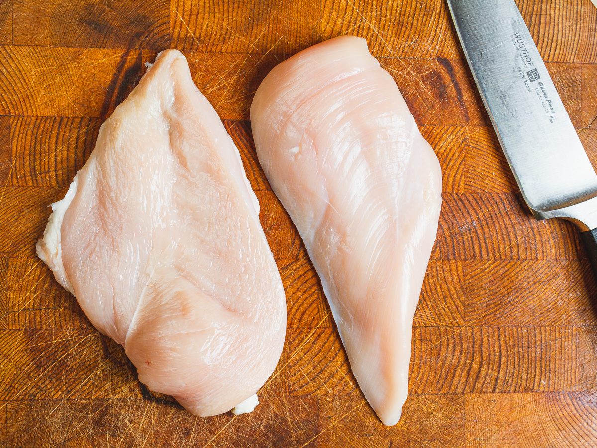 2 boneless skinless chicken breasts on a wooden surface.