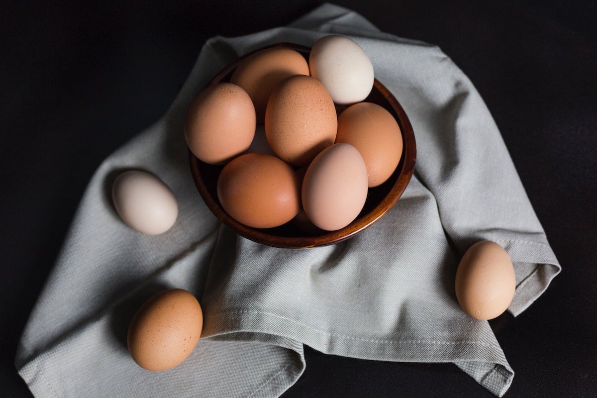 eggs in a bowl on a grey towel.