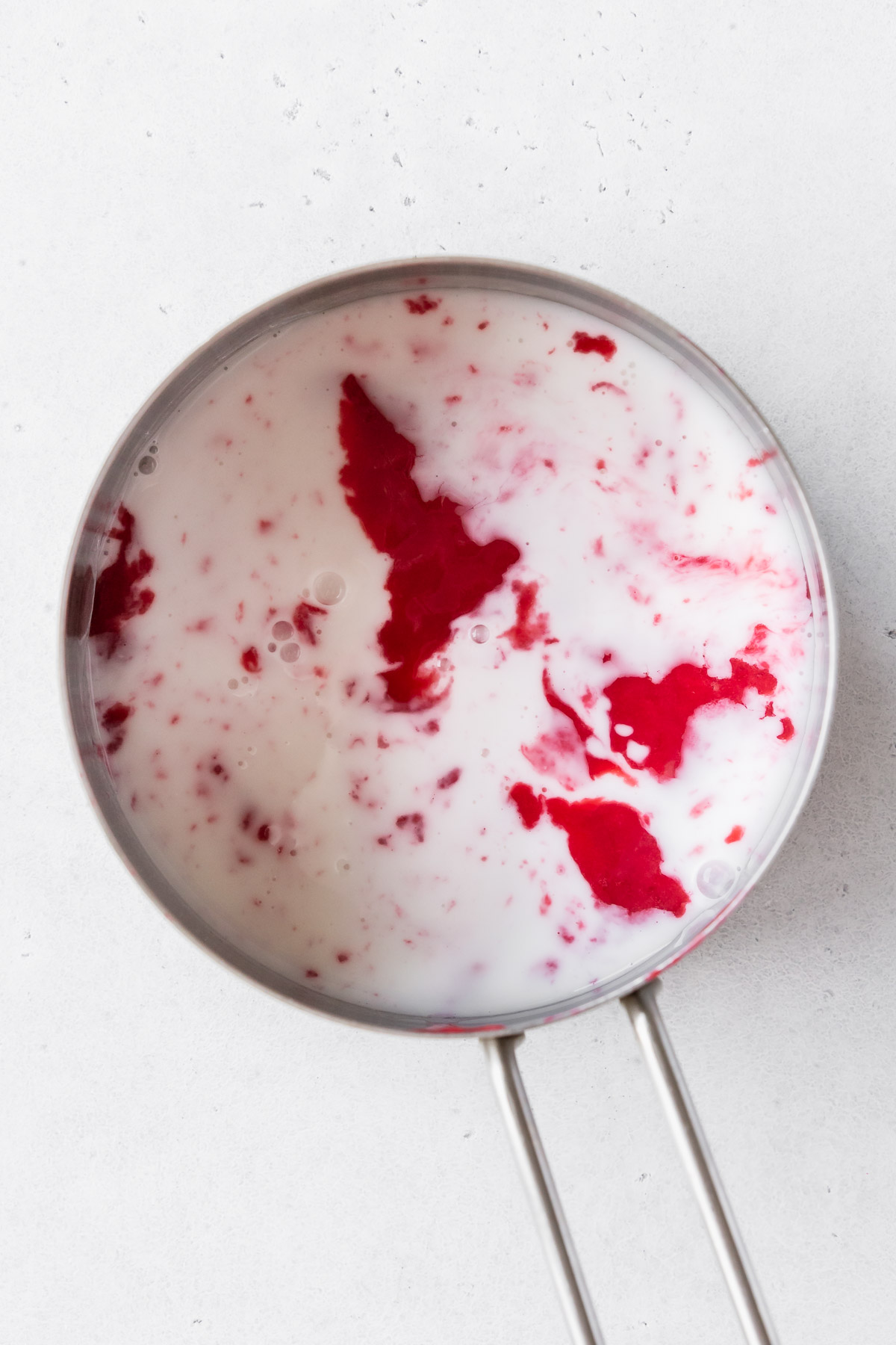 seedless raspberry purée and cream in a saucepan.