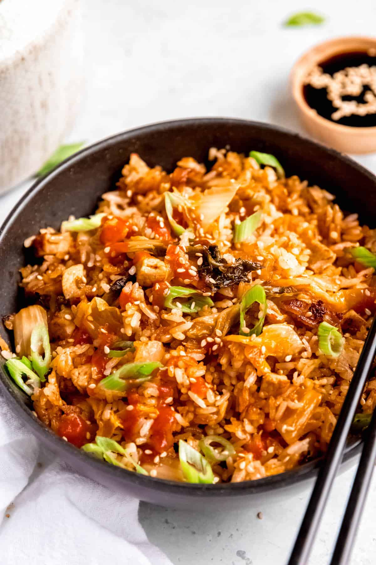 hero shot of a bowl of BBQ pork and gochujang fried rice garnished with scallions.