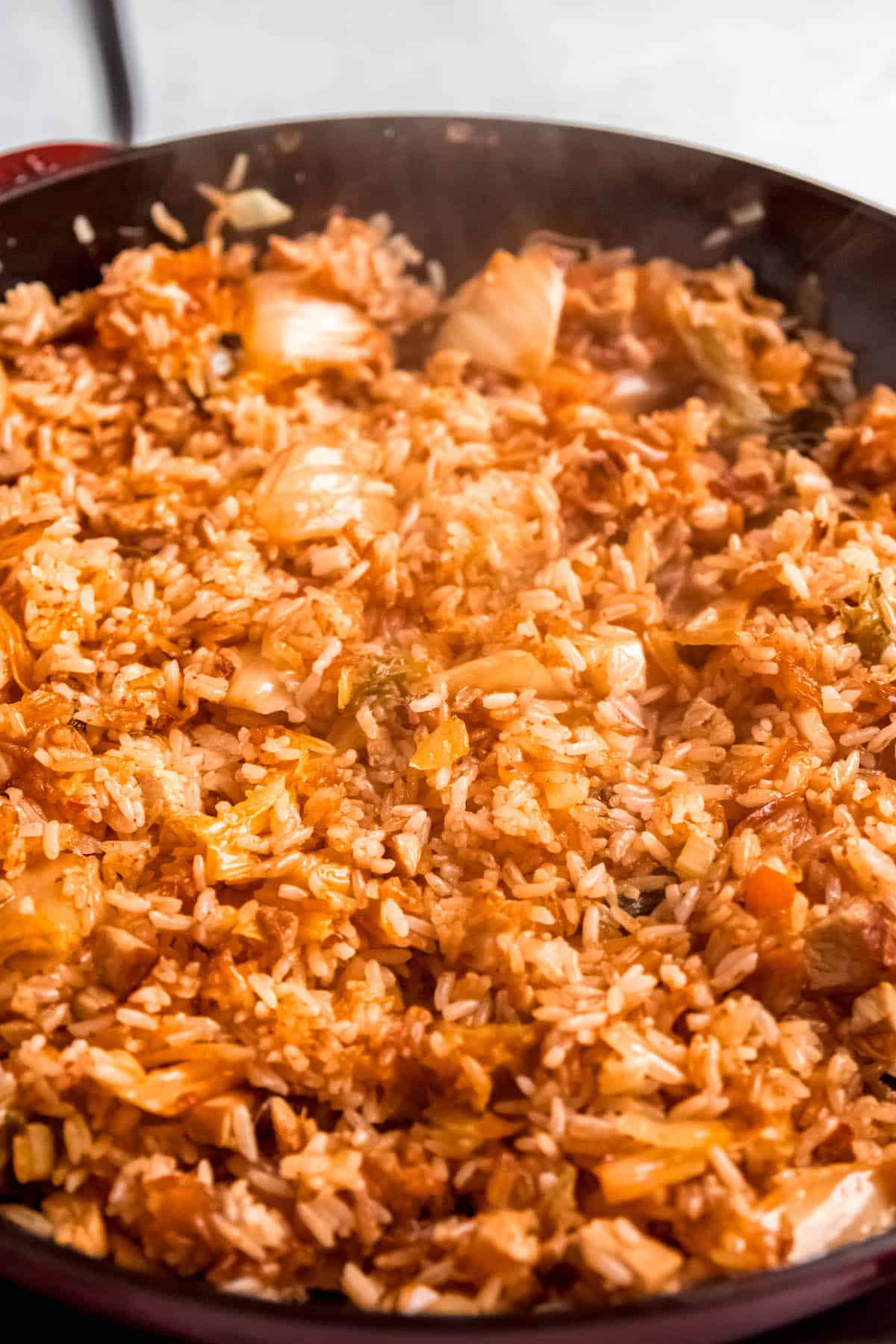 closeup shot of kimchi pork fried rice cooking in the skillet to get some crispy bits.