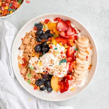 square hero image of healthy breakfast banana parfait with cool whip ice cream and fruity pebble sprinkles.