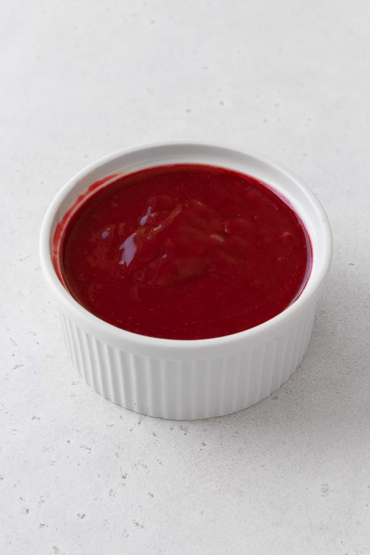 amaretto raspberry coulis in a white bowl.