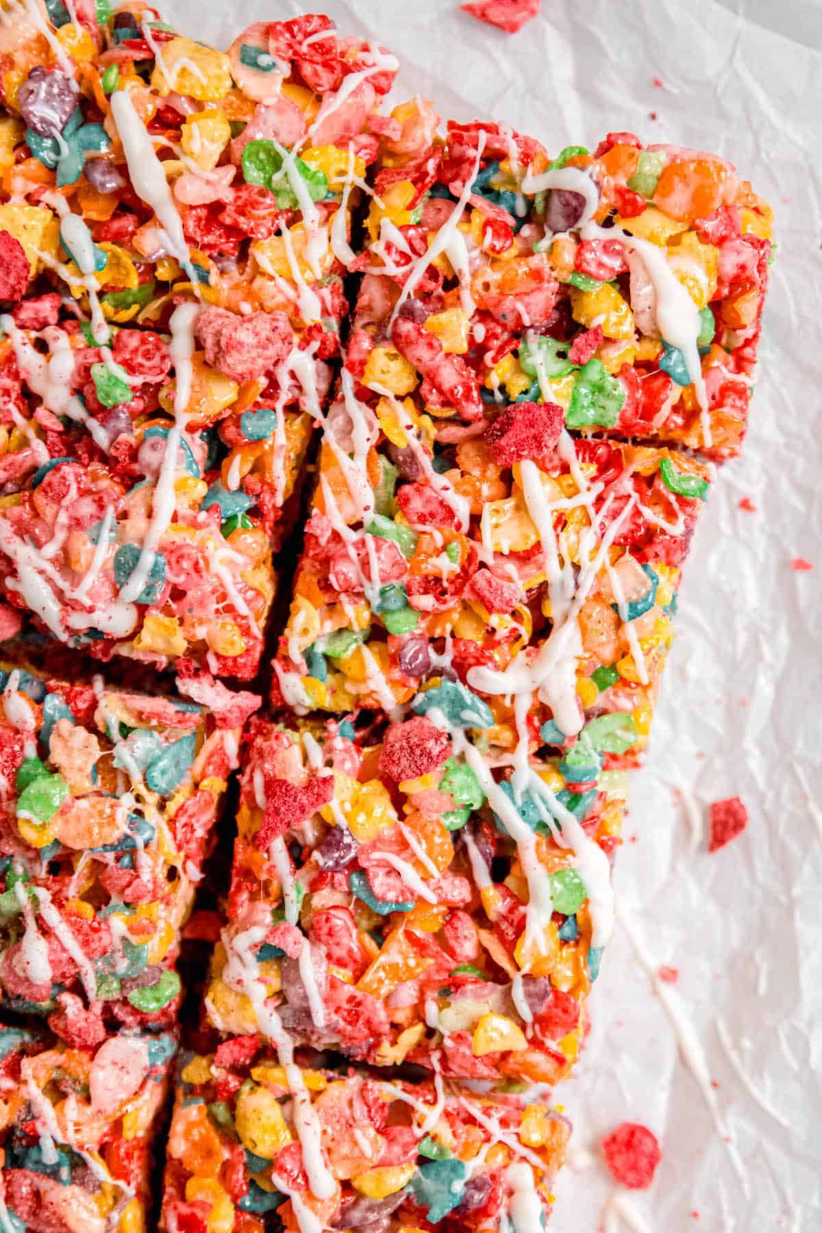 hero image of a batch of fruity pebbles cereal bars topped with strawberry white chocolate drizzle and freeze dried strawberry dust.