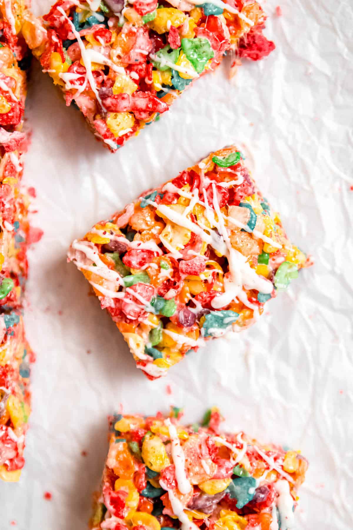 closeup hero image of fruity pebbles cereal bars after decorating with a strawberry white chocolate drizzle.