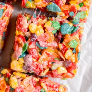 square hero image of a fruity pebbles cereal bar showing trails of stretchy marshmallow.