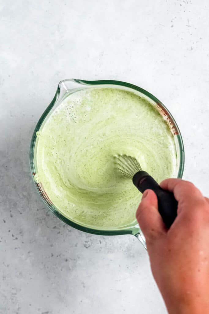 whisking together the matcha-green mint ice cream base in a large measuring cup.