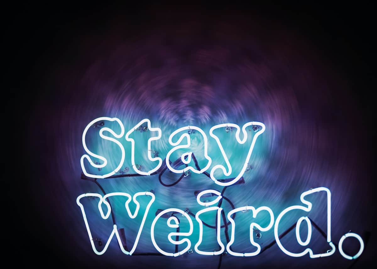 neon light that spells out "stay weird" in bubble letters.