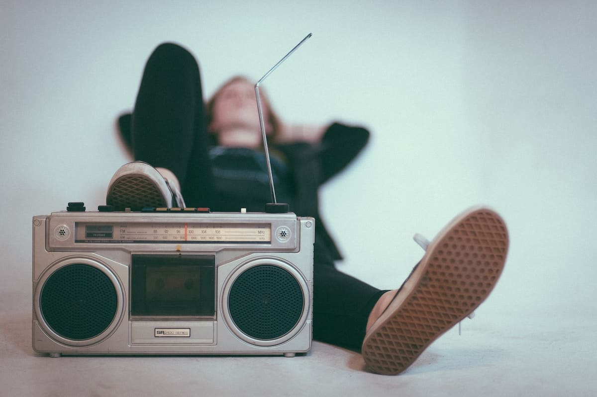 college kid laying on their back listening to a radio.