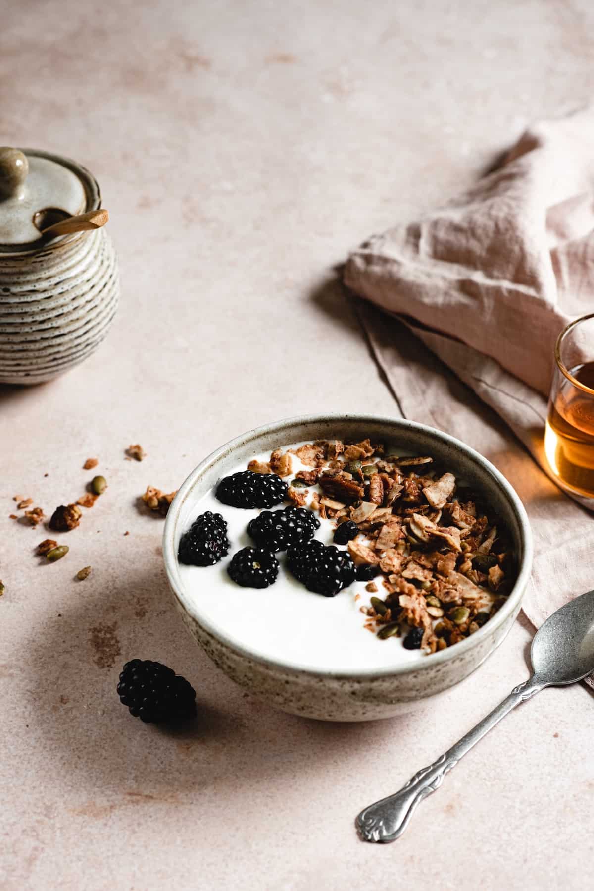 DIY granola on a bowl of yogurt with berries.