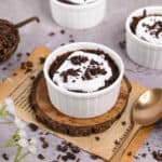 white ramekin filled with 30-second chocolate cake and topped with whipped cream and chocolate shavings.
