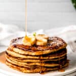 maple syrup spilling over a stack of oatmeal cottage cheese banana protein pancakes.
