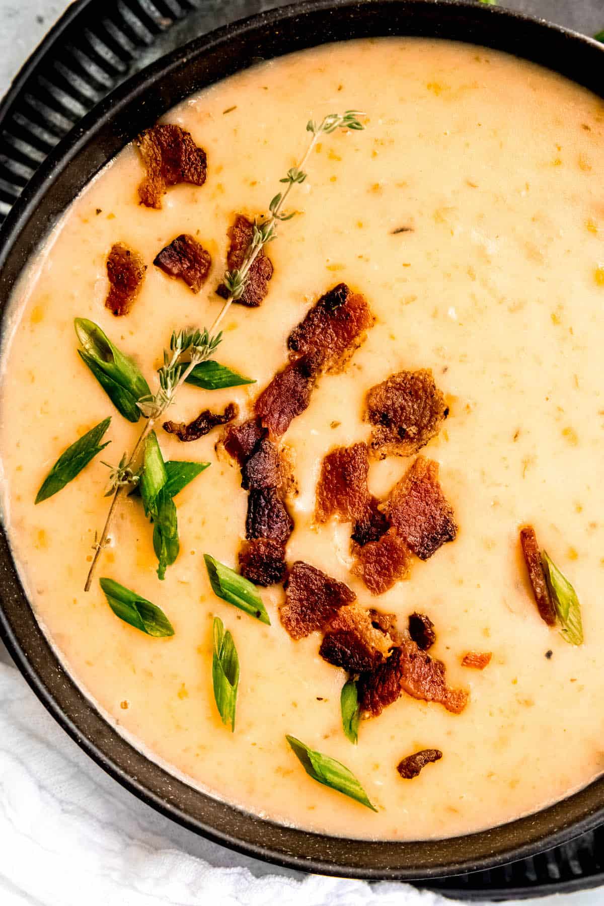 closeup shot of a bowl of gluten free potato soup garnished with bacon and green onions.