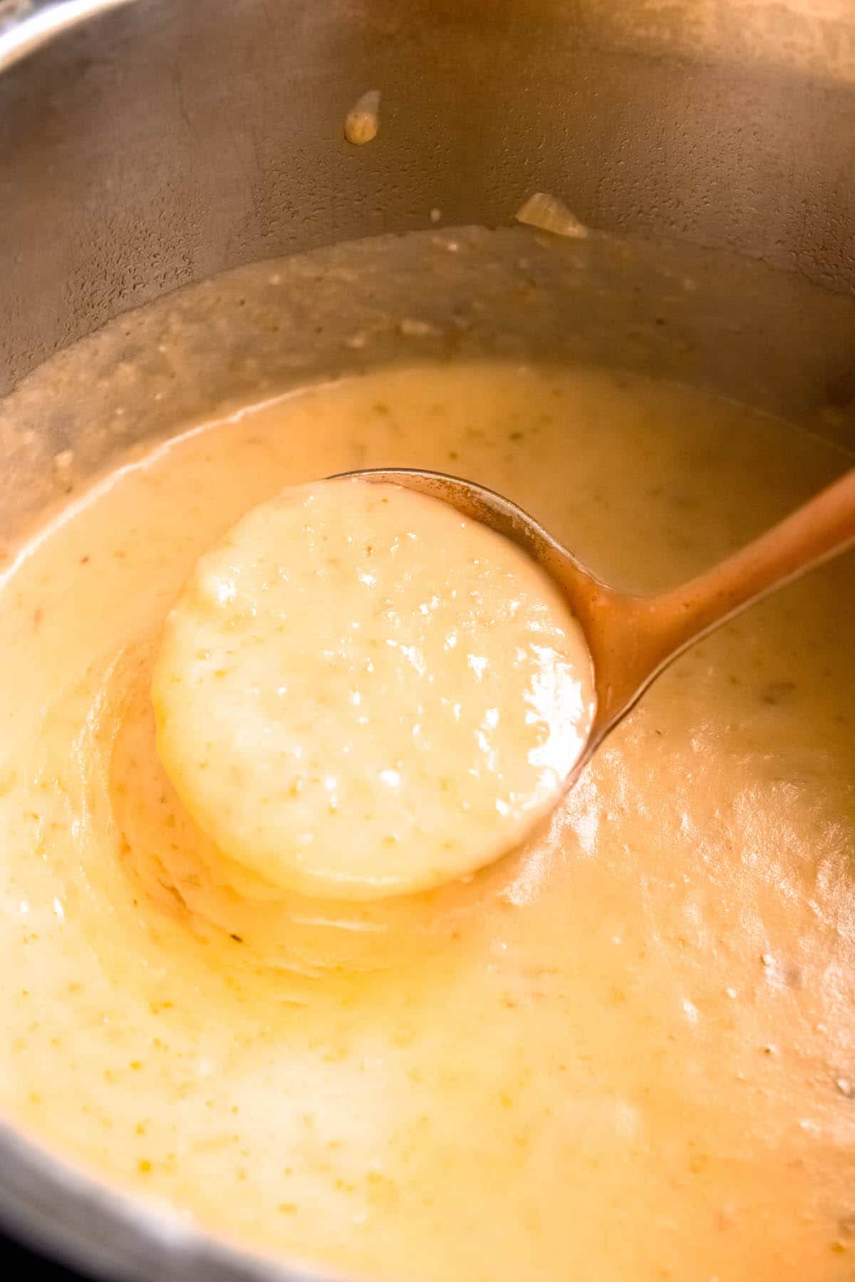 ladleful of creamy gluten free potato soup after blending till still slightly chunky.