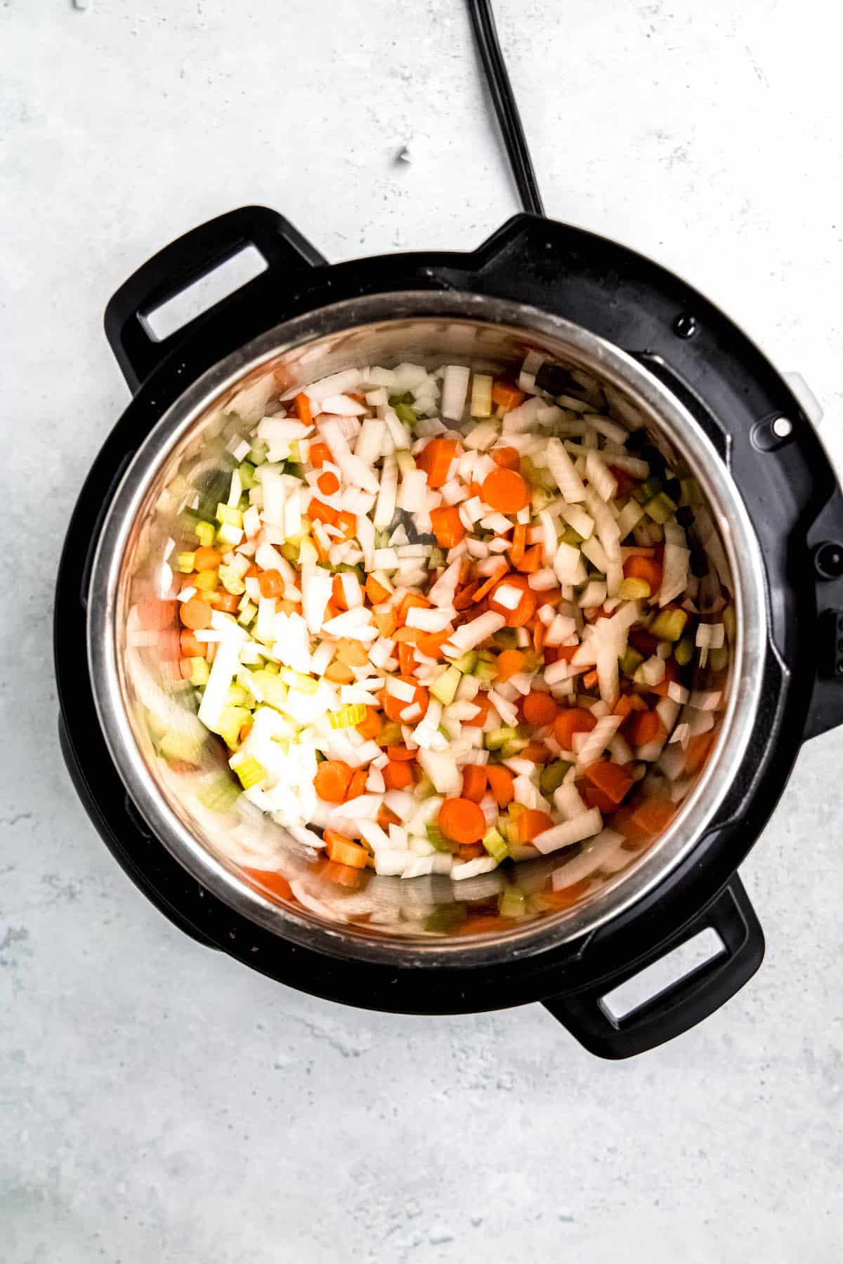 mirepoix being sauteed in the base of the instant pot.
