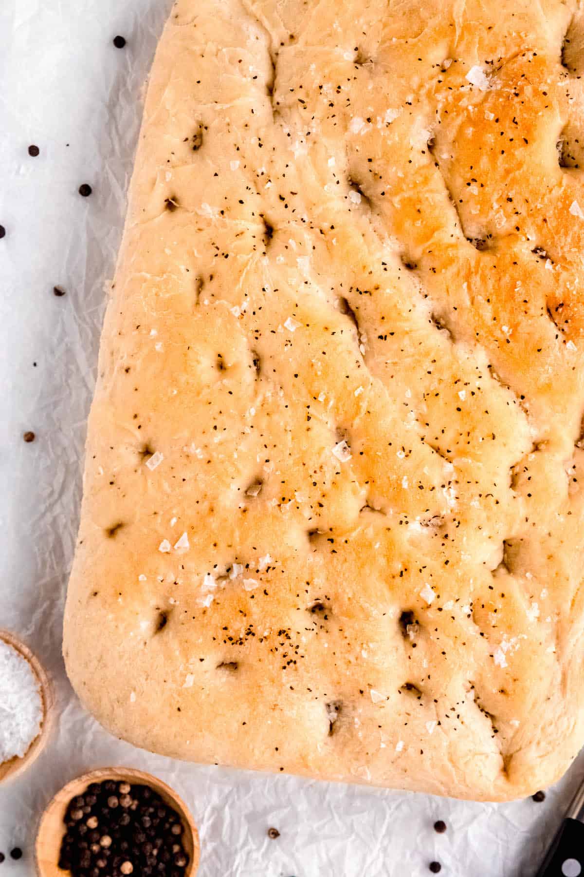 closeup overhead shot of the corner of the loaf of golden brown, fluffy black pepper focaccia.