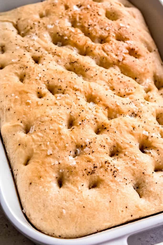 baked black pepper focaccia cooling in the baking pan.