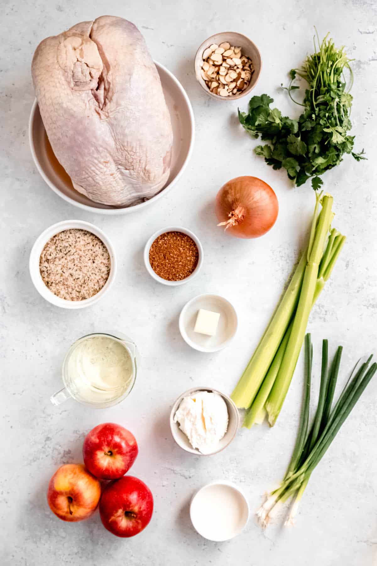 ingredients needed to make dutch oven turkey breast measured into bowls on a white table.