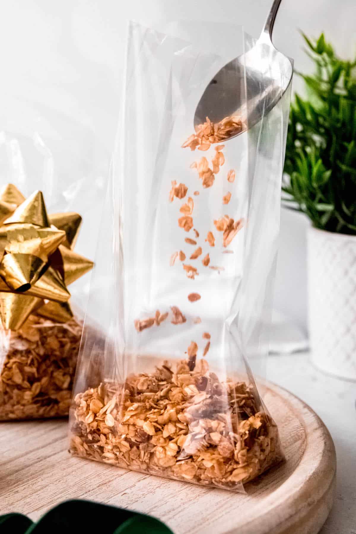 action shot of divvying up the bulk granola recipe into cellophane bags for gifting.
