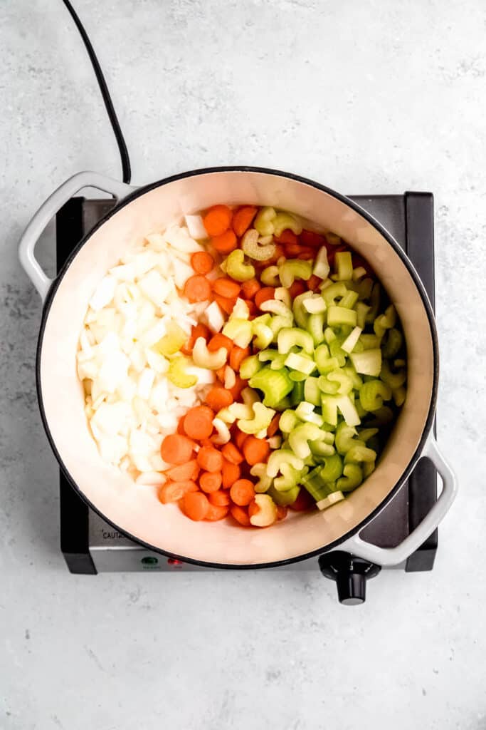 celery, carrots, and onions added to the base of a dutch oven to sauté for soup.