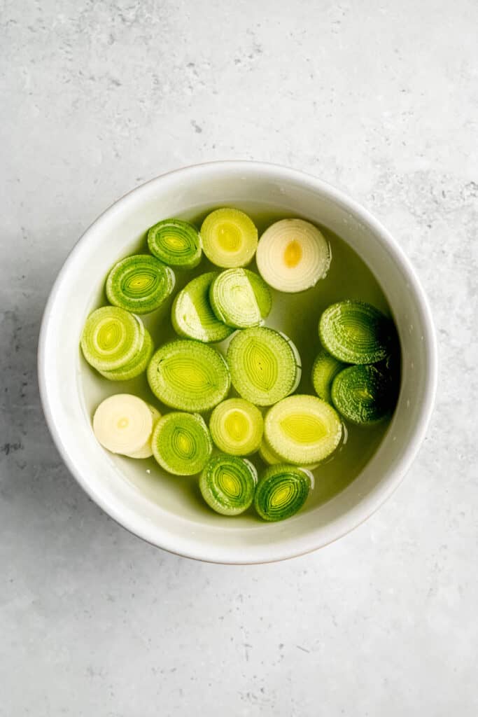 sliced leek rounds soaking in a bowl of cool water.