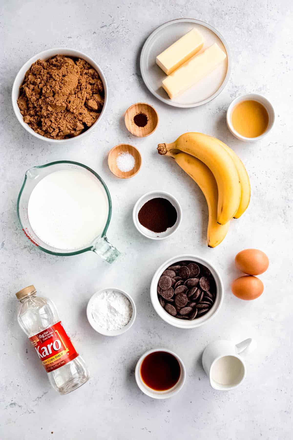 ingredients needed to make bananas foster pudding and chocolate coffee ganache measured out on a white table.
