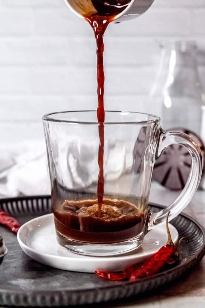 process shot - brewing espresso into a clear mug.