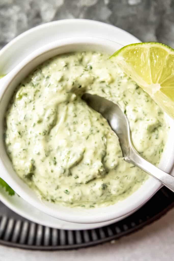 Chuy's style creamy jalapeño sauce in a white bowl for serving with tortilla chips.