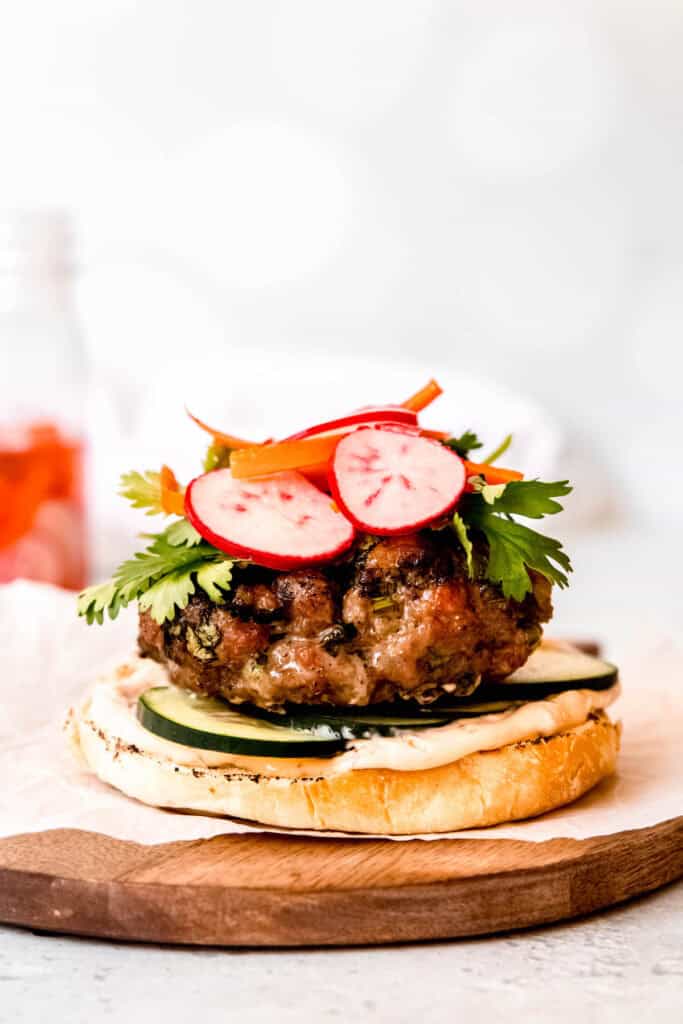 pickled radishes and carrots and fresh cilantro layered atop the burger patty.