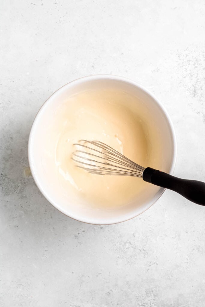 whisk in a bowl with the cream cheese mixture that's been mixed with some of the hot cream mixture until smooth.