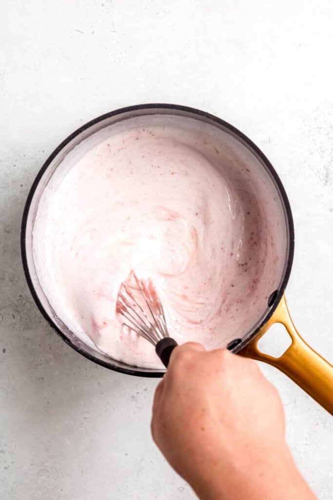 hand whisking the vanilla buttermilk ice cream base until pale pink and uniform.