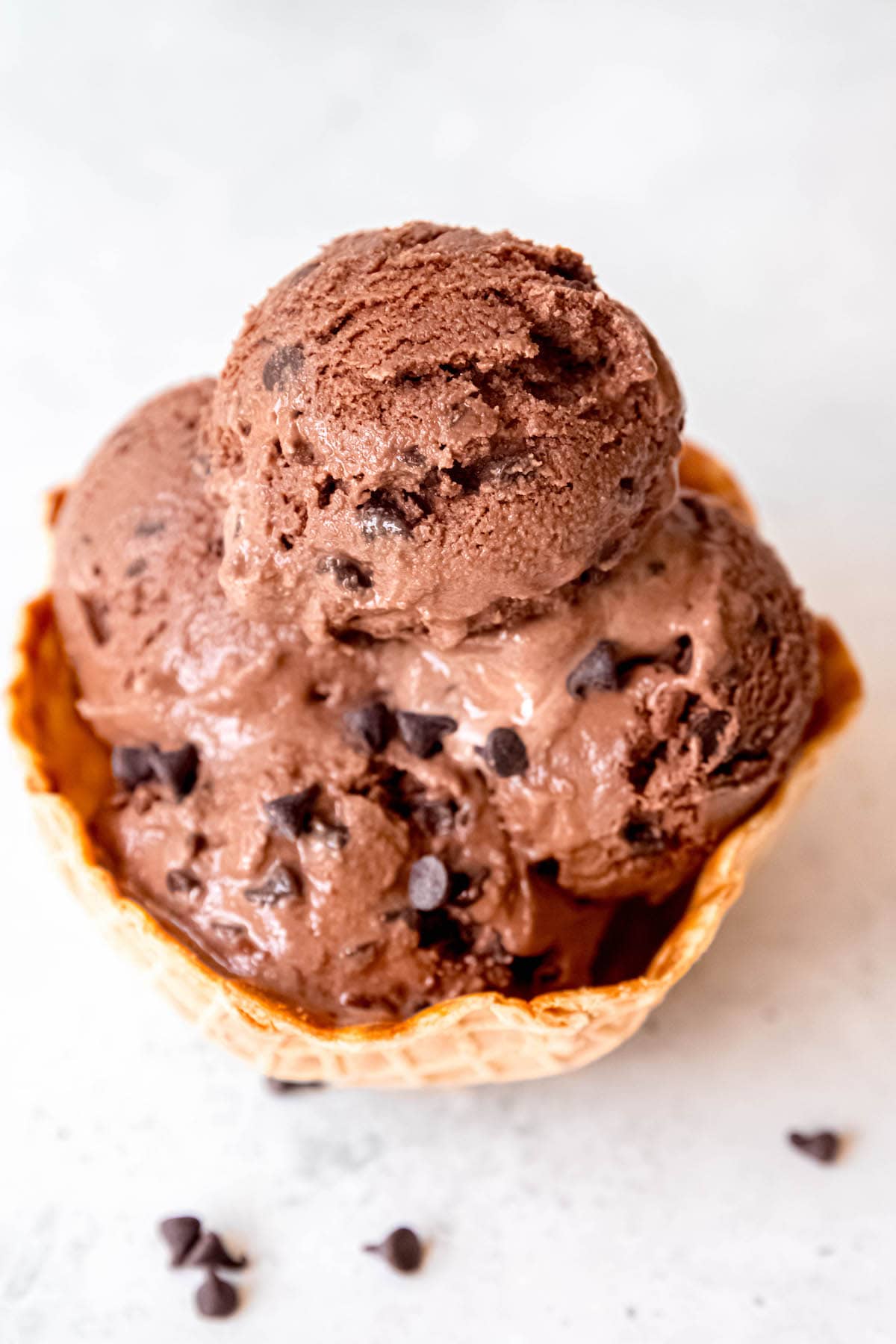 overhead shot of a waffle cone bowl filled with 4 or 5 scoops of homemade double chocolate chip ice cream.