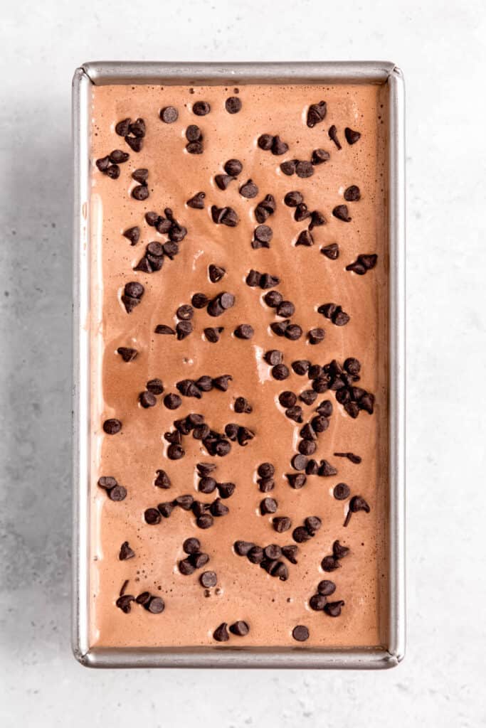 double chocolate ice cream after pouring into a loaf tin for freezing and topping with a scattering of mini chocolate chips.