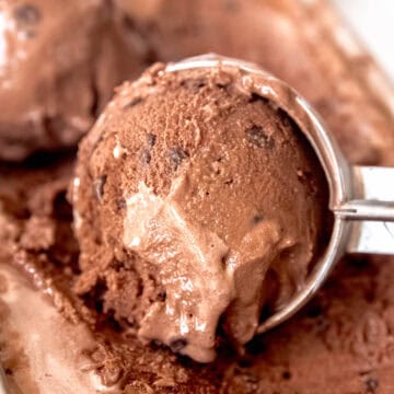 ice cream scoop taking a scoop of double chocolate chip ice cream in a silver loaf tin.