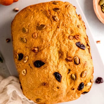 closeup shot of pumpkin machine bread on a table before slicing.