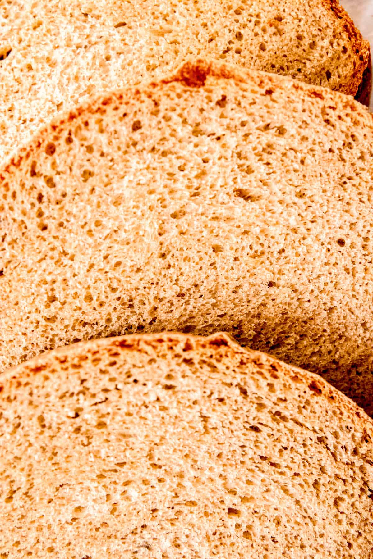 close up shot of three overlapping slices of sourdough discard sandwich bread.