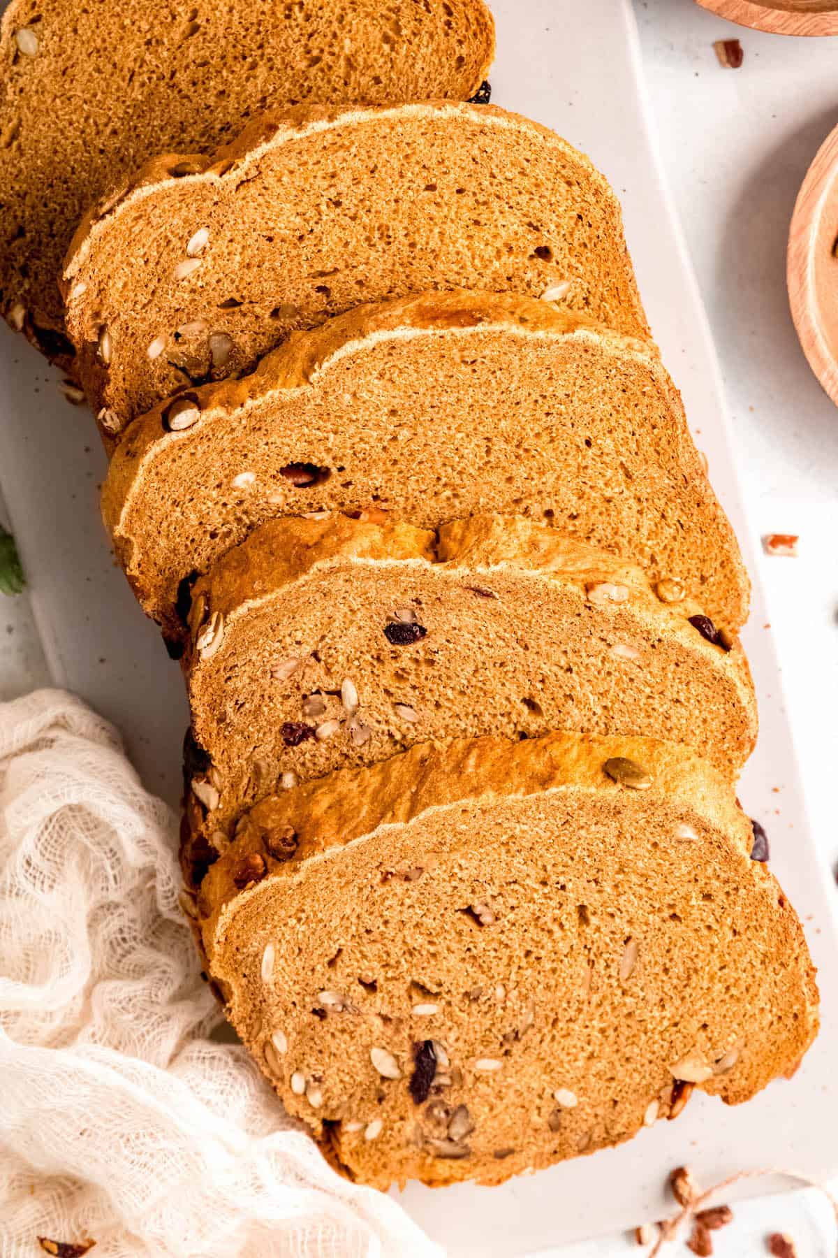 closeup shot of slices of yeasted bread machine pumpkin bread on a white table with a white linen.