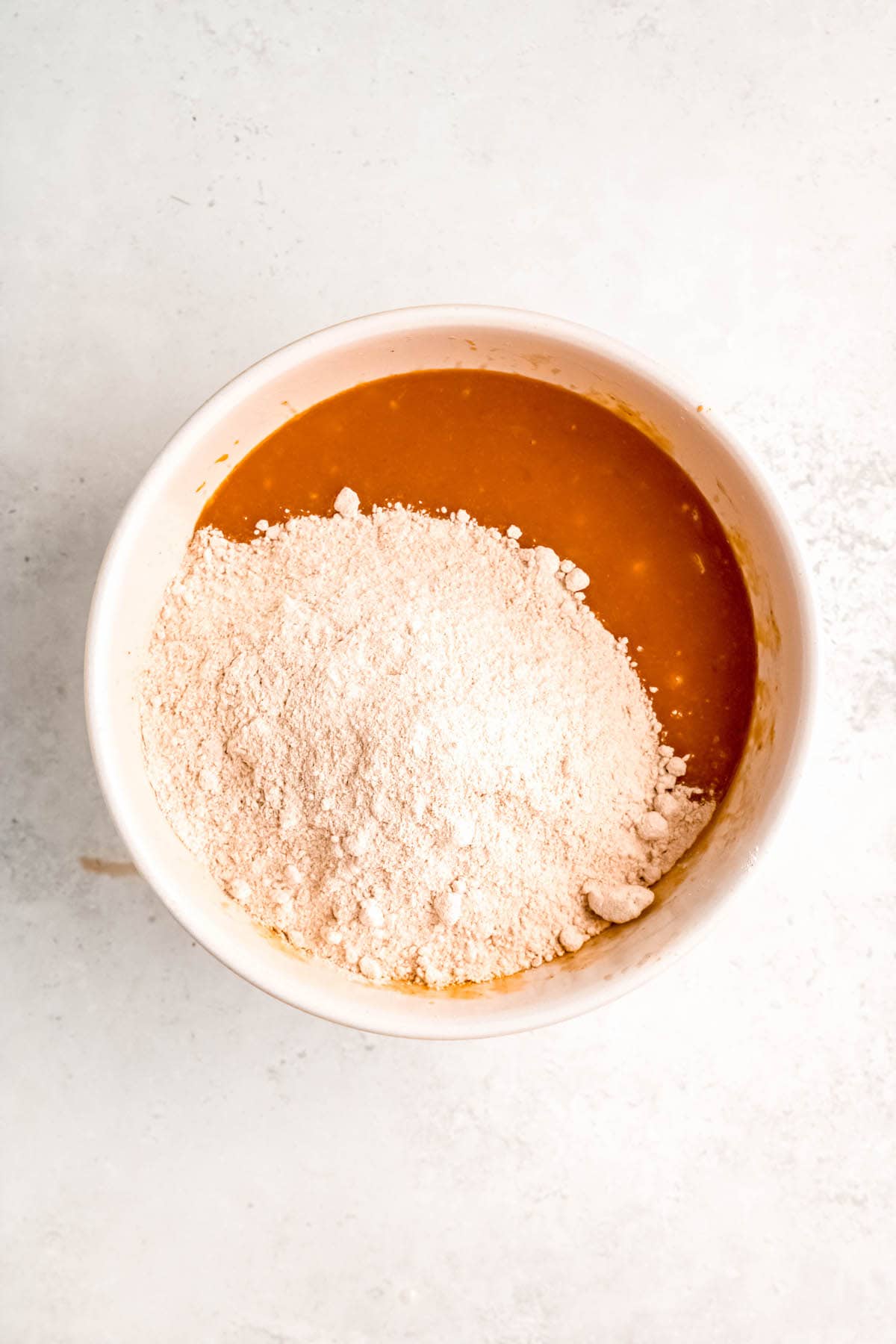 dry ingredients added to the bowl with the butter, banana, and pumpkin mixture.