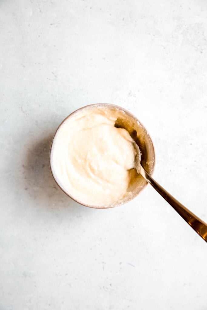 ricotta and honey in a small mixing bowl after stirring together with a silver spoon.