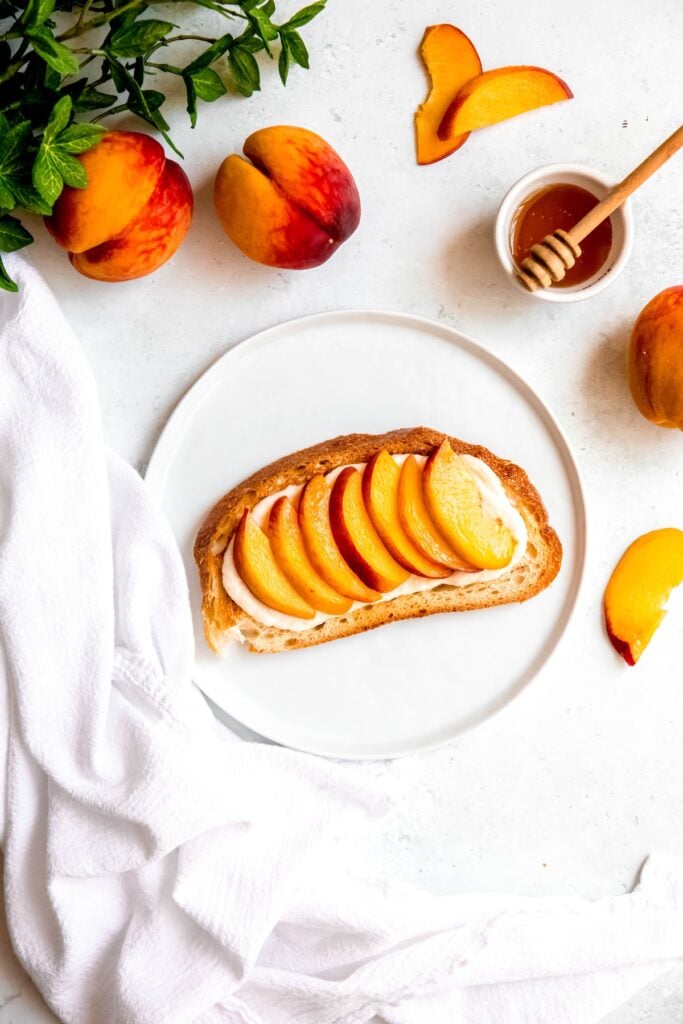 peach slices laid atop the ricotta mixture spread on the toast.